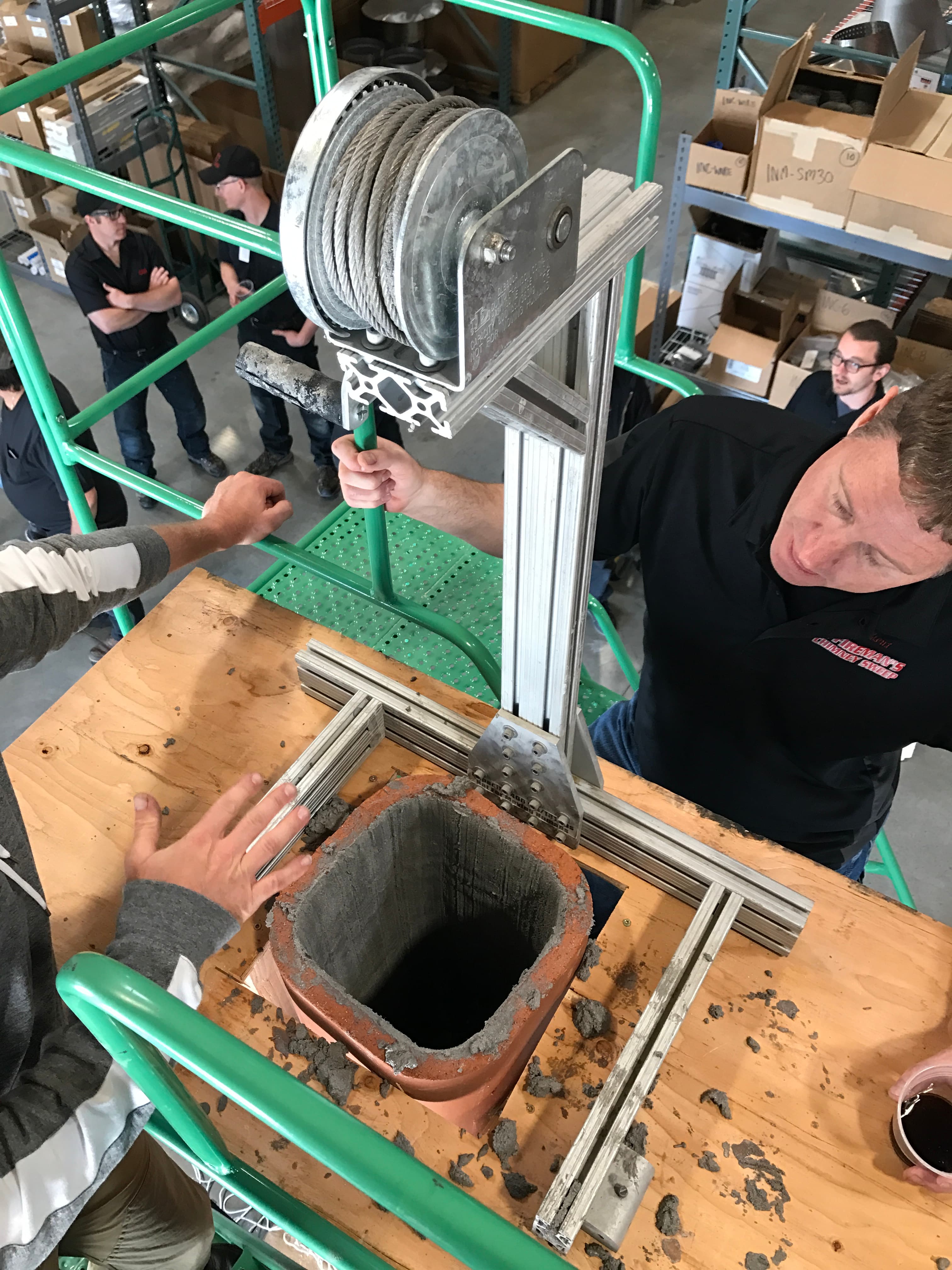 AFCS technician examining a clay tile flue liner at certification training